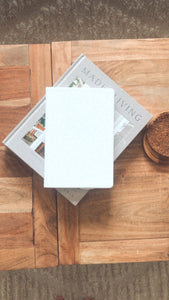 white notebook on wood coffee table with gray book